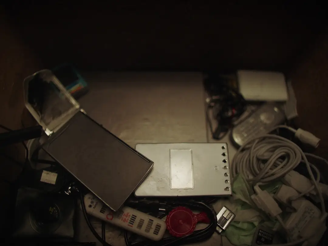 a drawer stuffed with old phones, tangled chargers and an external hard drive